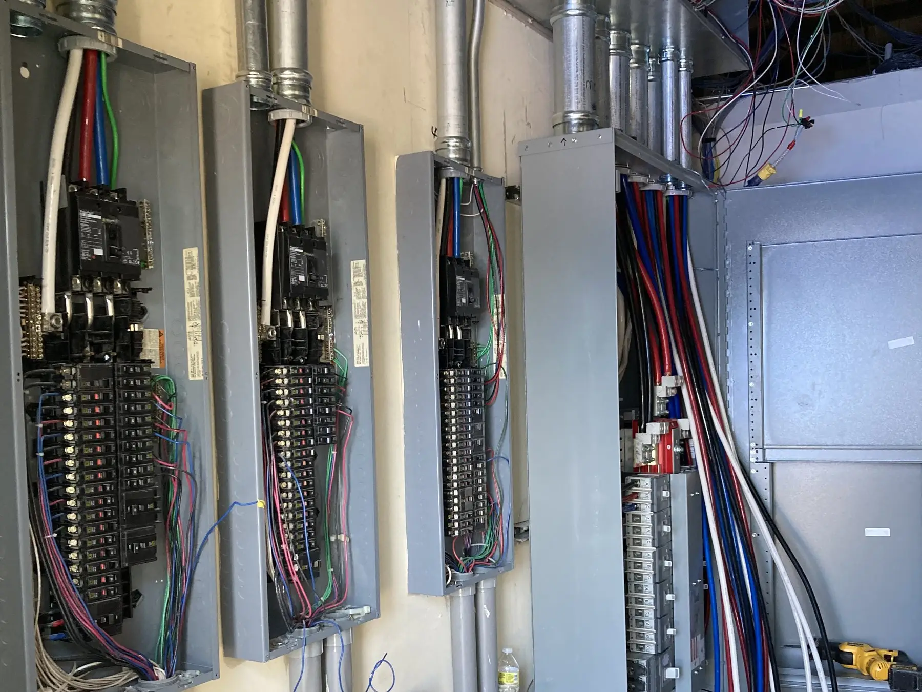 Panels and wiring gutters with colour-coded conductors run between them